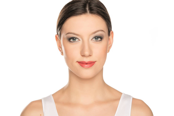 retrato de una joven hermosa mujer con ojos azules y maquillaje sobre un fondo blanco - Foto, imagen