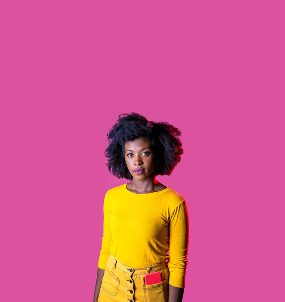 若いです黒女性posing隔離された視線フレンドリーでリラックス上のピンク広告コピースペースの背景 - 写真・画像