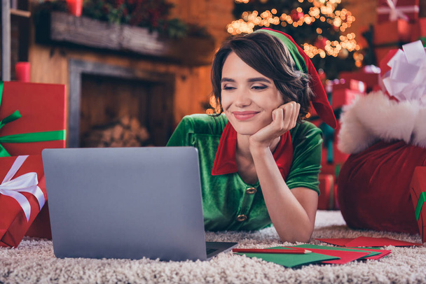 Photo of cute dreamy young lady wear elf clothes reading modern device writing letters smiling indoors house home room - 写真・画像