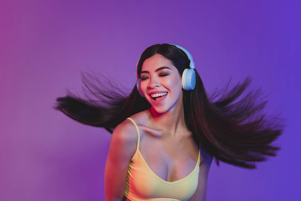 Portrait of lovely trendy dreamy cheery girl listening hit having fun rest pastime isolated over shine purple violet color background - Foto, Imagem