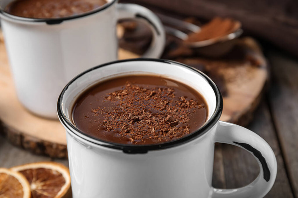 Tassen mit leckerer heißer Schokolade auf Holzgrund, Nahaufnahme - Foto, Bild