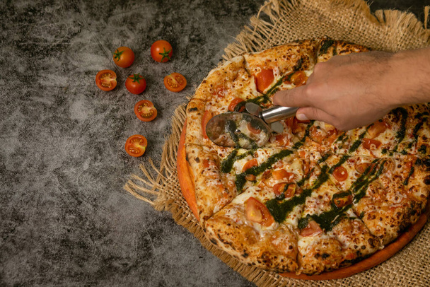 A delicious pizza Napoletana / Neapolitan with tomatoes, mozzarella and basil - Zdjęcie, obraz