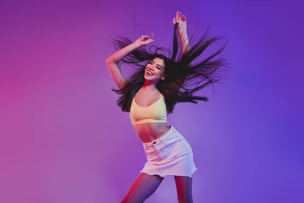 Portrait of attractive cheerful carefree girl dancing clubbing isolated over vivid violet purple neon color background - Foto, Bild