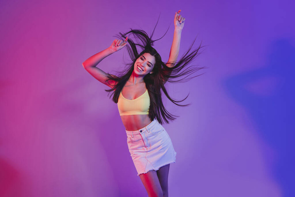 Portrait of attractive cheerful dreamy girl dancing posing chill isolated over vivid violet purple neon color background - Photo, image