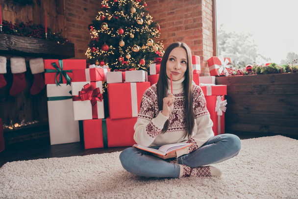 Full size photo of dream young lady write list sit near present tree wear sweater jeans socks christmas at home - Foto, afbeelding