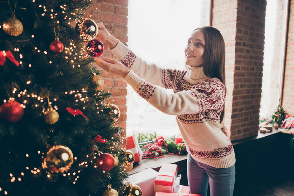 Photo of charming shiny mature woman wear print sweater smiling decorating christmas tree indoors house home room - Фото, изображение