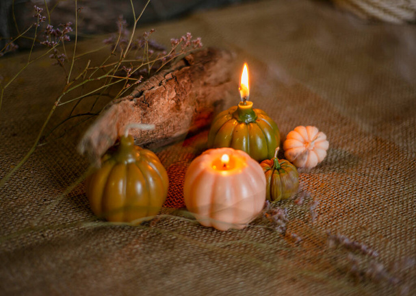 candles with the shape of pumpkins for Halloween, white, golden pumpkins and lighted candles, magic atmosphere of a romantic evening, Halloween concept. - Photo, Image