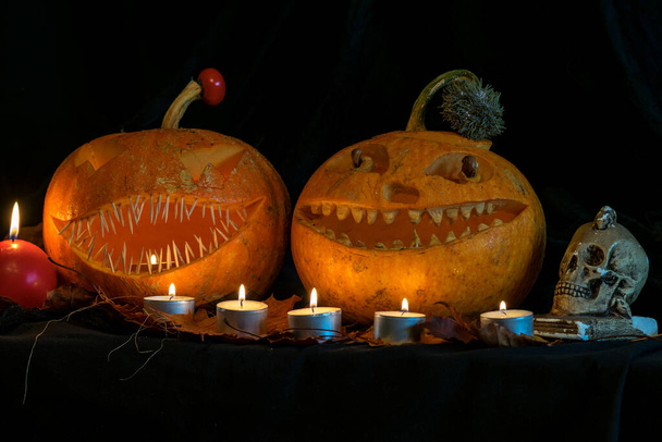 Halloween thema, gesneden pompoen met een enge glimlach, brandende kaarsen, spinnen en spinnenwebben, afschuwelijke schedels, decoratie en vakantie concept, gesneden pompoen voor een leuk feestje, Jack O 's lantaarn - Foto, afbeelding