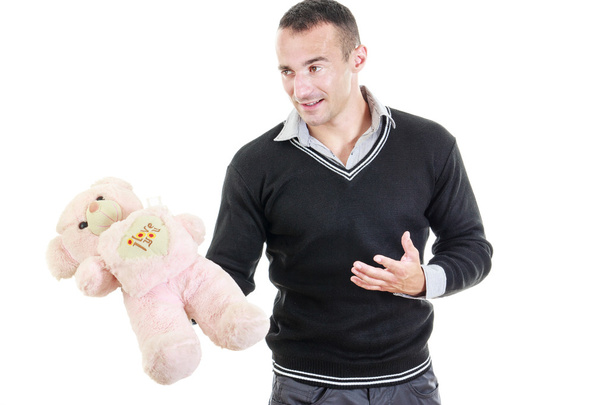 Молодой человек держит плюшевого медведя в качестве подарка
 - Фото, изображение