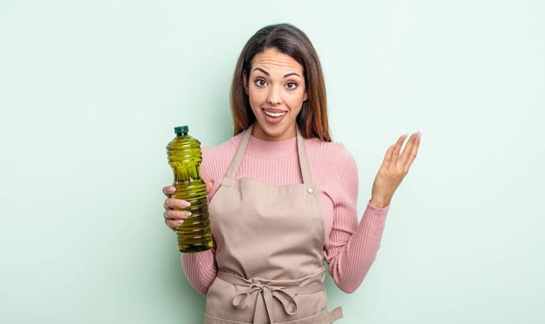 pretty hispanic woman feeling happy, surprised realizing a solution or idea. olive oil concept - Foto, Imagen