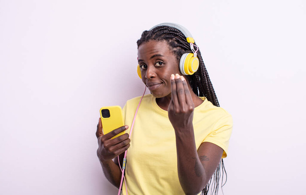 pretty black woman making capice or money gesture, telling you to pay. listening music concept - Φωτογραφία, εικόνα