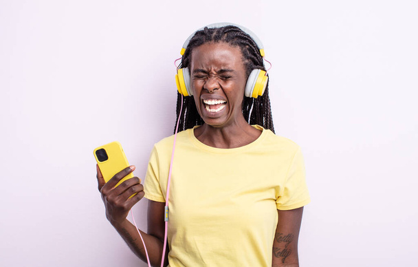 pretty black woman shouting aggressively, looking very angry. listening music concept - Photo, Image