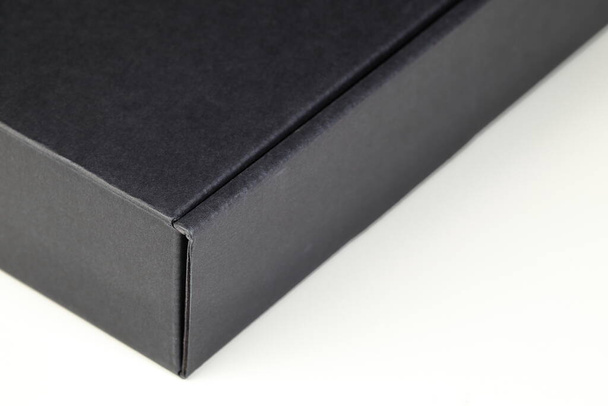 Правый угол картонного ящика черного квадрата для доставки посылок изолирован на белом фоне - Фото, изображение