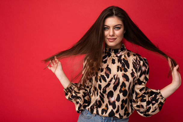 Fashion photo of young beautiful fashionable sexy brunette woman wearing stylish leopard blouse isolated on red background with empty space - Photo, Image