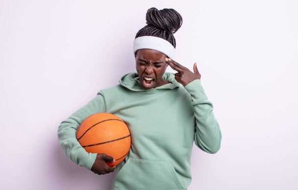 pretty black woman looking unhappy and stressed, suicide gesture making gun sign. basketball concept - Fotografie, Obrázek