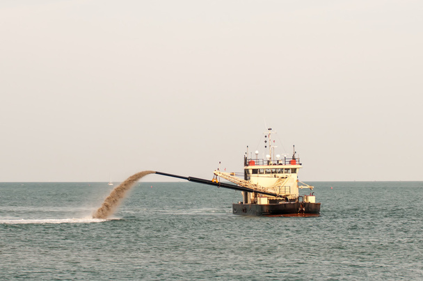 Tubo de barcaça empurrando areia para a praia
 - Foto, Imagem