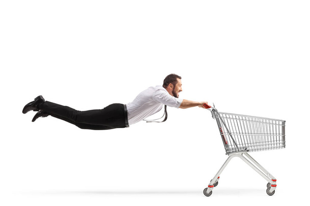 Man flying with an empty shopping cart isolated on white background - Φωτογραφία, εικόνα