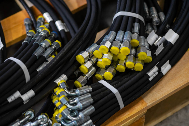 Pakiet nowych wysokociśnieniowych przewodów hydraulicznych w opakowaniu. Węże hydrauliczne z żółtymi wtyczkami - Zdjęcie, obraz