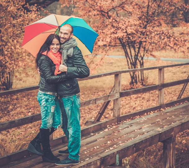Happy middle-aged couple with umbrella outdoors on beautiful rainy autumn day   - Fotoğraf, Görsel