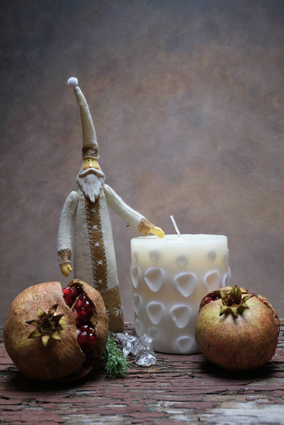 Joulupukki juurien, kynttilöiden ja granaattiomenan joukossa - Valokuva, kuva