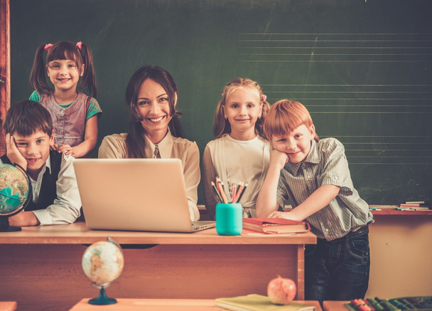 Група щасливих однокласників зі своїм вчителем у класі біля дошки
  - Фото, зображення