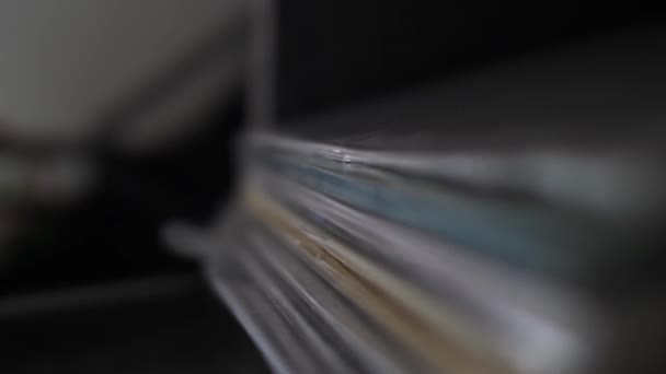 Primer vídeo vertical de la mano de un DJ mientras abre la tapa de su caja de vinilo, revelando su colección de álbumes y comienza a buscar su pista preferida - Imágenes, Vídeo
