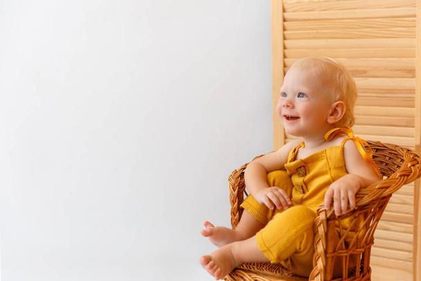 Vauva poika istuu puinen nojatuoli ja hymyilee. - Valokuva, kuva