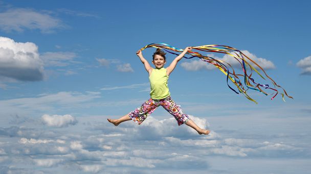 happy little girl with colorful ribbons on blue sky - Photo, Image