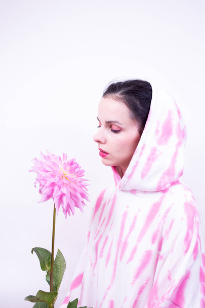 woman in a pink hoodie holding a pink flower - Foto, Imagem