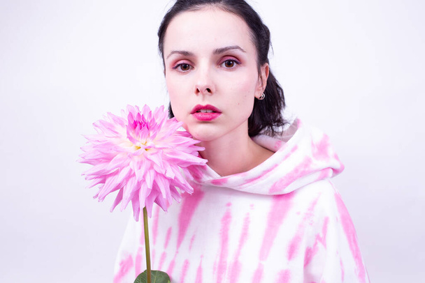 woman holding pink flower - Fotoğraf, Görsel