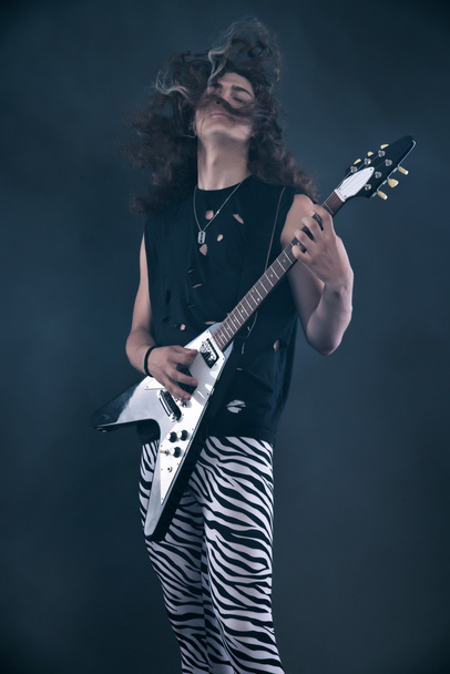 αρσενικό σκληρό ροκ μουσικός ηλεκτρική κιθάρα με μακριά μαλλιά. στούντιο με - Φωτογραφία, εικόνα