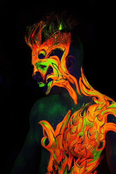 Body art glowing in ultraviolet light  - Фото, изображение