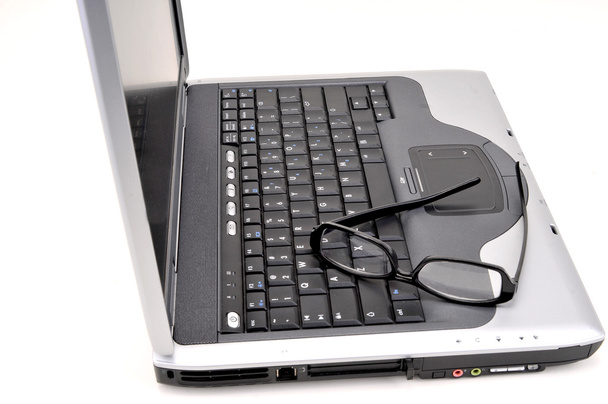 Laptop aberto com óculos pretos
 - Foto, Imagem