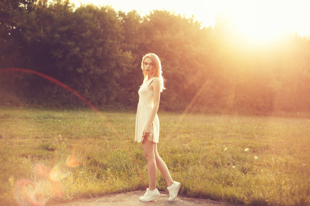 meisje in het park in een witte jurk op een zonnige dag - Foto, afbeelding