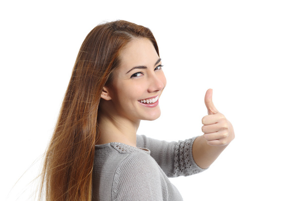 Back view of a happy woman making thumb up gesture - Foto, imagen