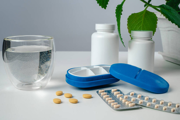 Top view of six day pill box with pills. Blue pill-box over light marble table. Open pill box and open boxes with pills or vitamins. Pill box for senior patient - Fotografie, Obrázek