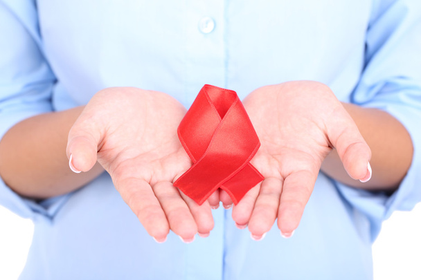 Woman with aids awareness red ribbon in hands isolated on white - Photo, image