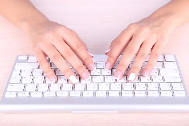 Female hands typing on keyboard, close-up, on light background - Foto, Imagen
