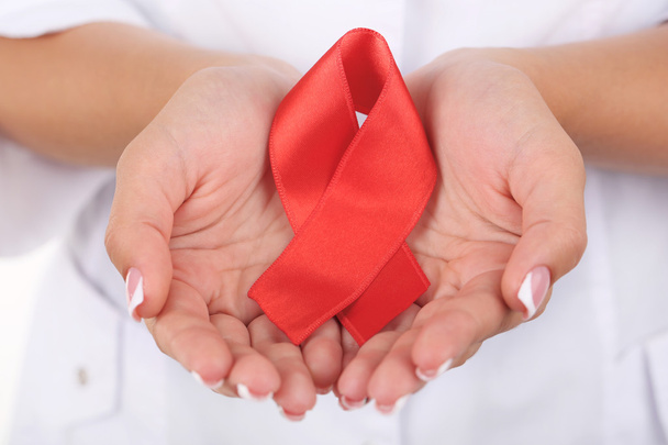 Woman with aids awareness red ribbon in hands isolated on white - Φωτογραφία, εικόνα