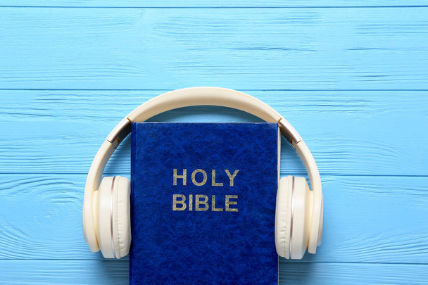Święta Biblia i nowoczesne słuchawki na drewnianym tle - Zdjęcie, obraz
