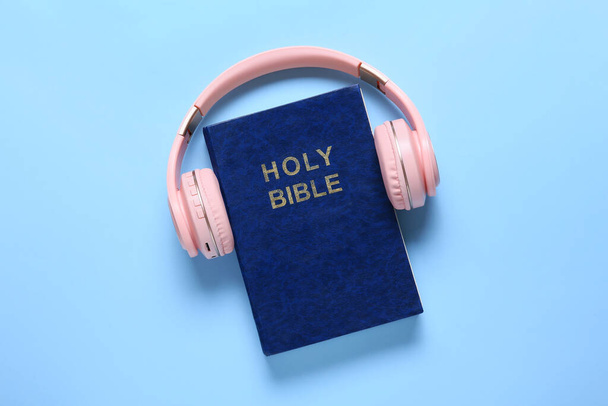 Święta Biblia i nowoczesne słuchawki na kolorowym tle - Zdjęcie, obraz
