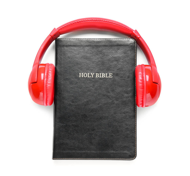 Bíblia Sagrada e fones de ouvido modernos em fundo branco - Foto, Imagem