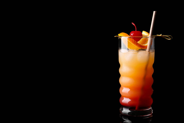 Glass of tasty Tequila Sunrise cocktail on dark background - Foto, Imagem