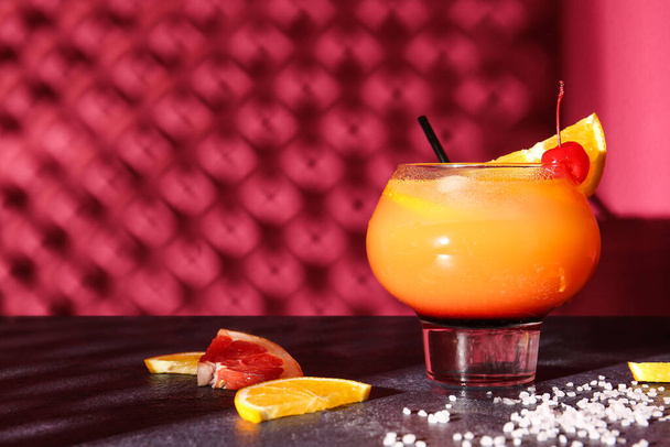 Vaso de sabroso cóctel Tequila Sunrise en la mesa contra el fondo de color - Foto, imagen