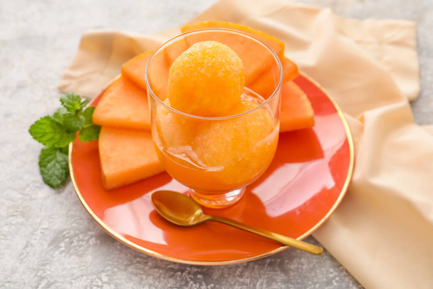 Bowl with delicious sorbet, melon pieces and mint on light background - Photo, Image