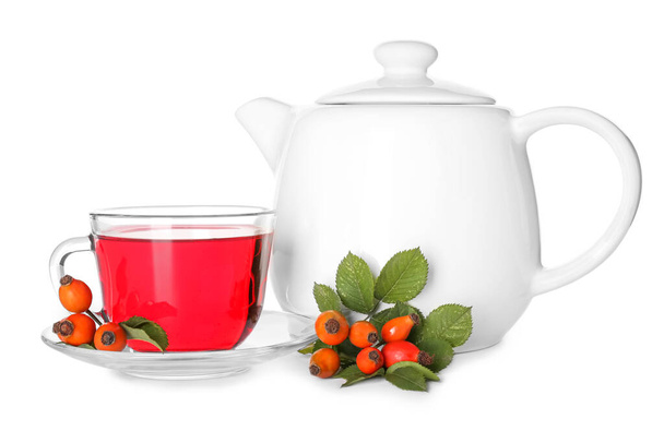 Glass cup tea pot of tasty rose hip beverage and berries on white background - Photo, Image