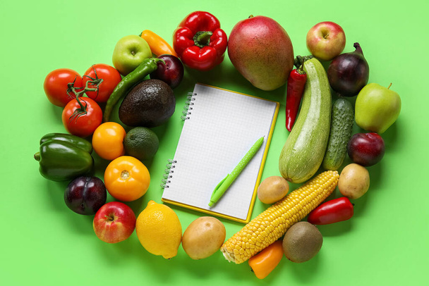 Blank notebook, pen, fruits and vegetables on green background. Vegan Day - Zdjęcie, obraz