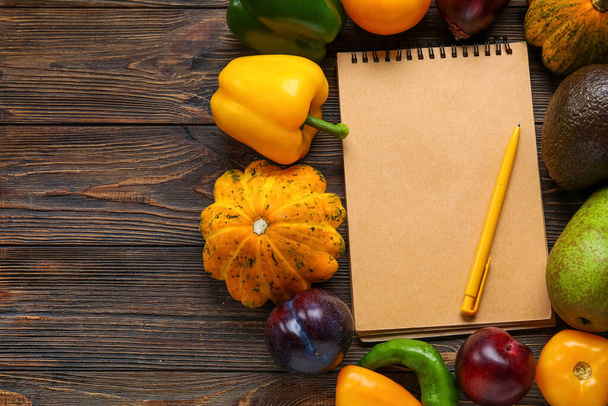 Blocco note, penna, verdura e frutta in bianco su sfondo legno. Vegan Day, primo piano - Foto, immagini