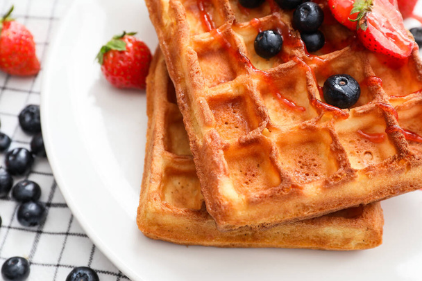 Plate of tasty Belgian Waffles with berries on table, closeup - Foto, imagen