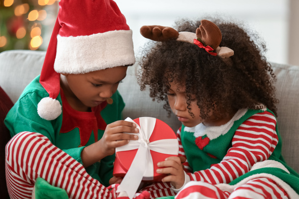 Pequeños niños afroamericanos con regalo de Navidad en casa - Foto, Imagen